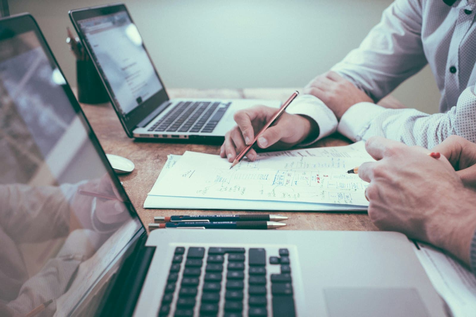 A practitioner reviewing paperwork at a desk. The same purpose test that decides whether a treatment is GST-free decides whether the invoice for it is too